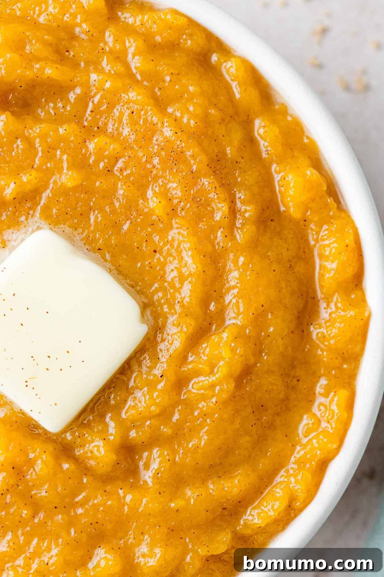 Butter melting on a bowl of mashed squash.