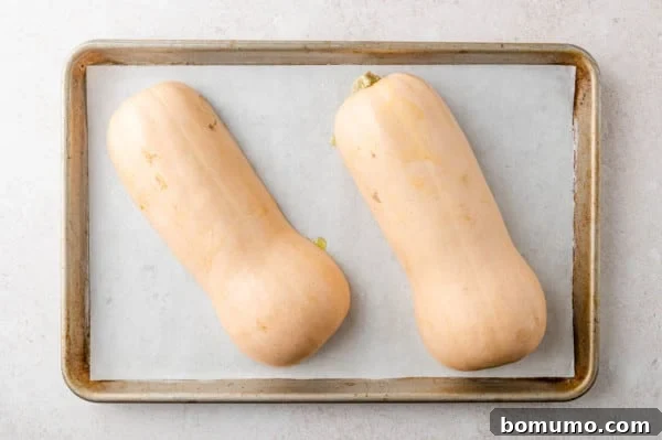 Uncooked squash placed face down on baking sheet.