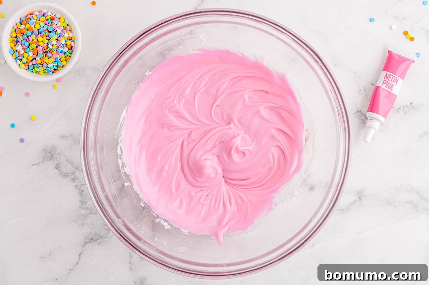 Pink frosting in a bowl.