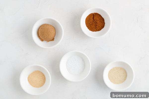 The essential spice blend ingredients laid out for your homemade BBQ salmon rub. A selection of individual spices including brown sugar, chili powder, garlic powder, onion powder, and salt, ready to be combined for the BBQ salmon dry rub.