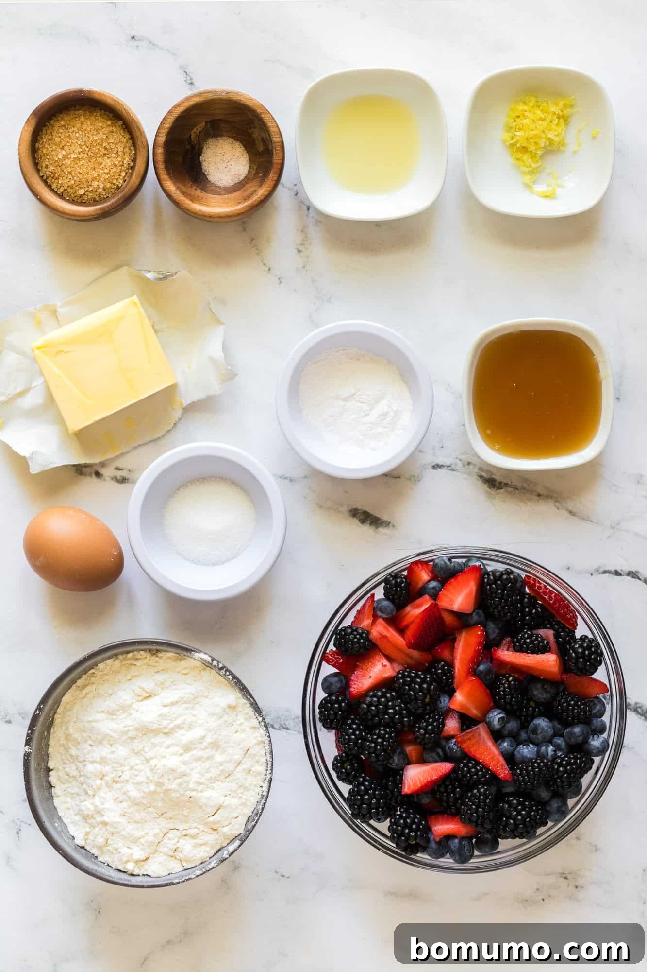 An overhead shot displaying all the fresh ingredients meticulously arranged for the berry galette recipe, ready for preparation.