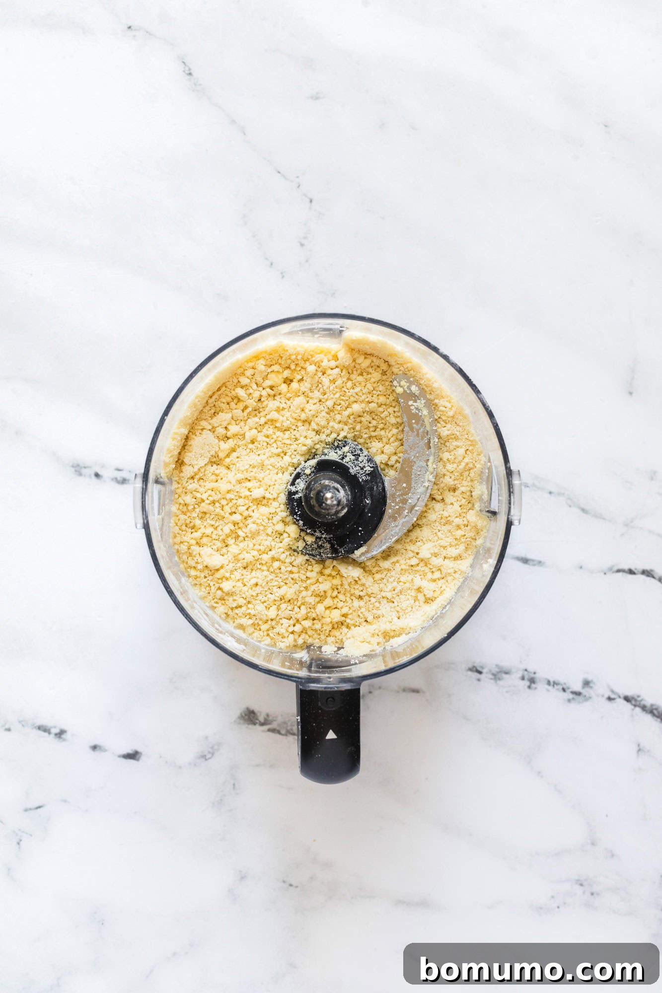 An overhead shot of the pie crust dough, perfectly prepared in a food processor.