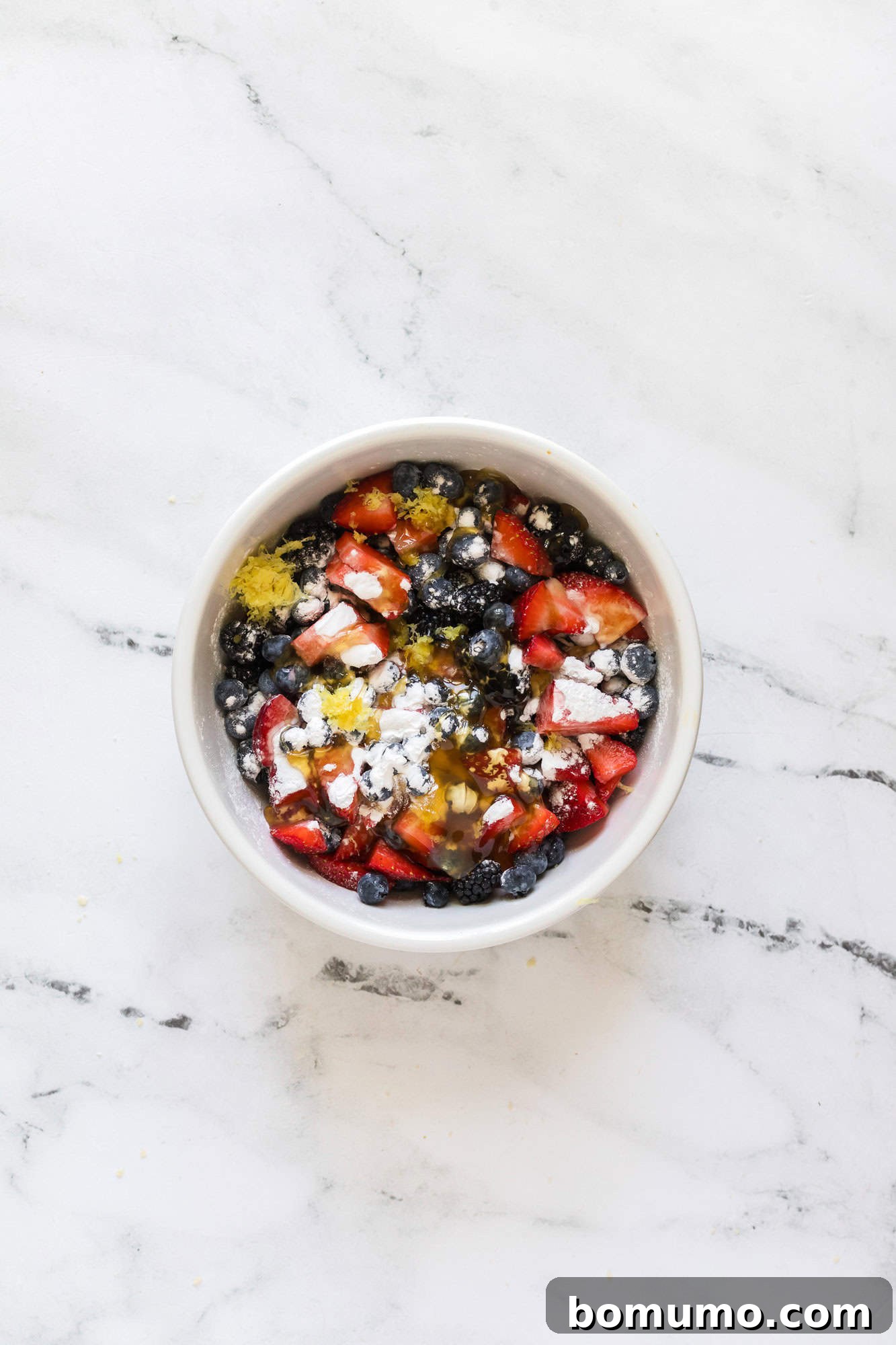 All ingredients for the berry filling neatly arranged in a white bowl, prior to mixing.