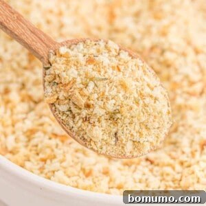 Homemade bread crumbs on a wooden spoon and in a bowl.