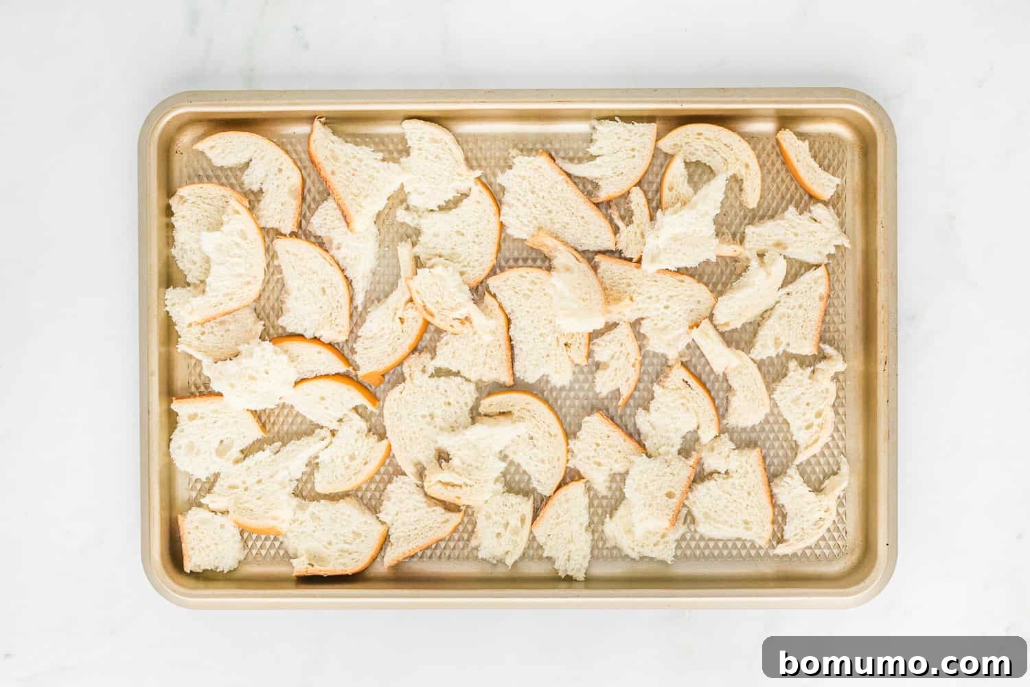 Torn bread on a baking sheet.