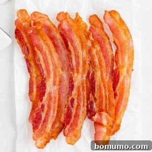 Crispy air fryer bacon on a white background, invitingly presented.