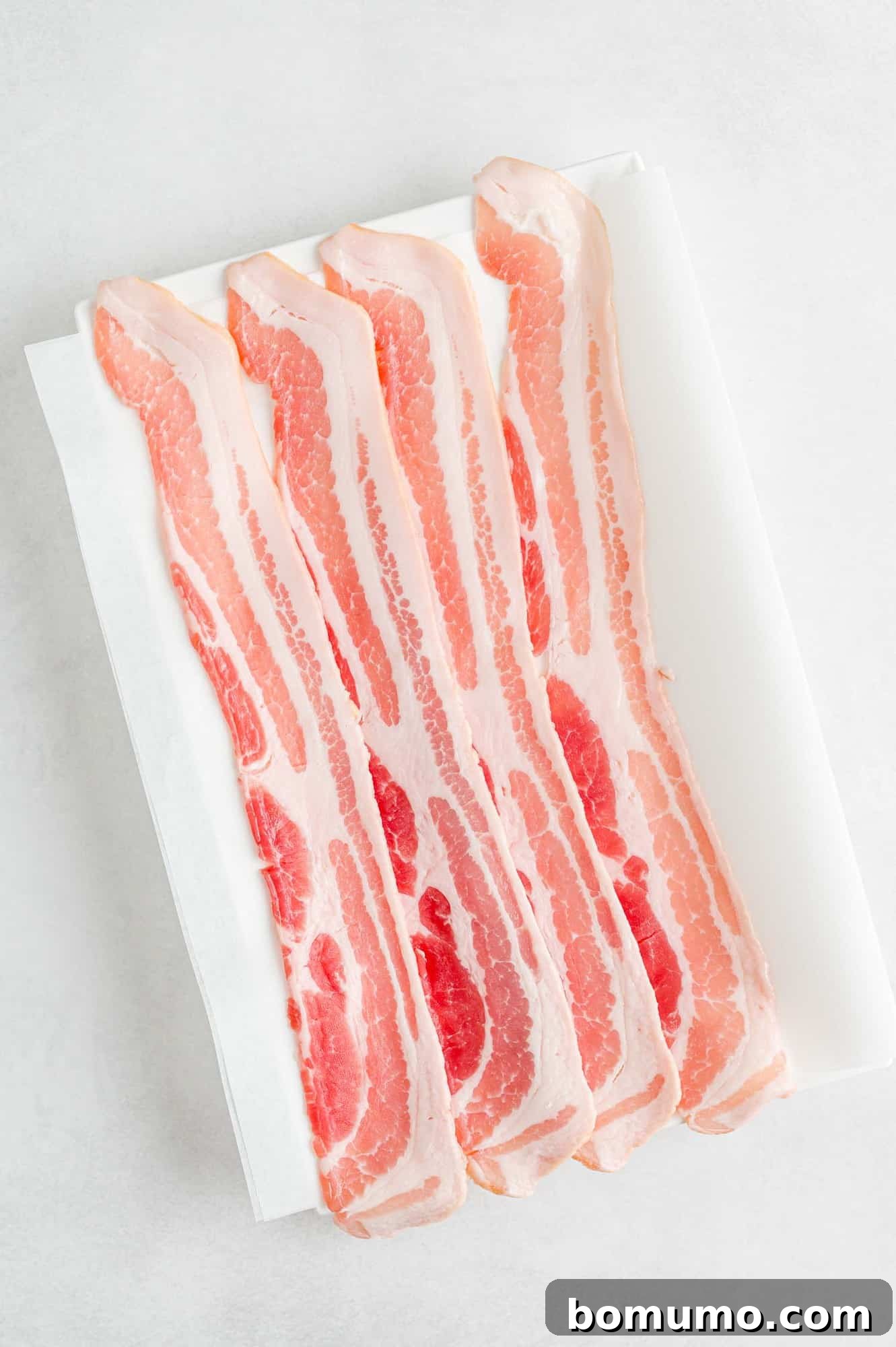 Crispy Air Fried Bacon 4 Raw, uncooked bacon slices neatly arranged.