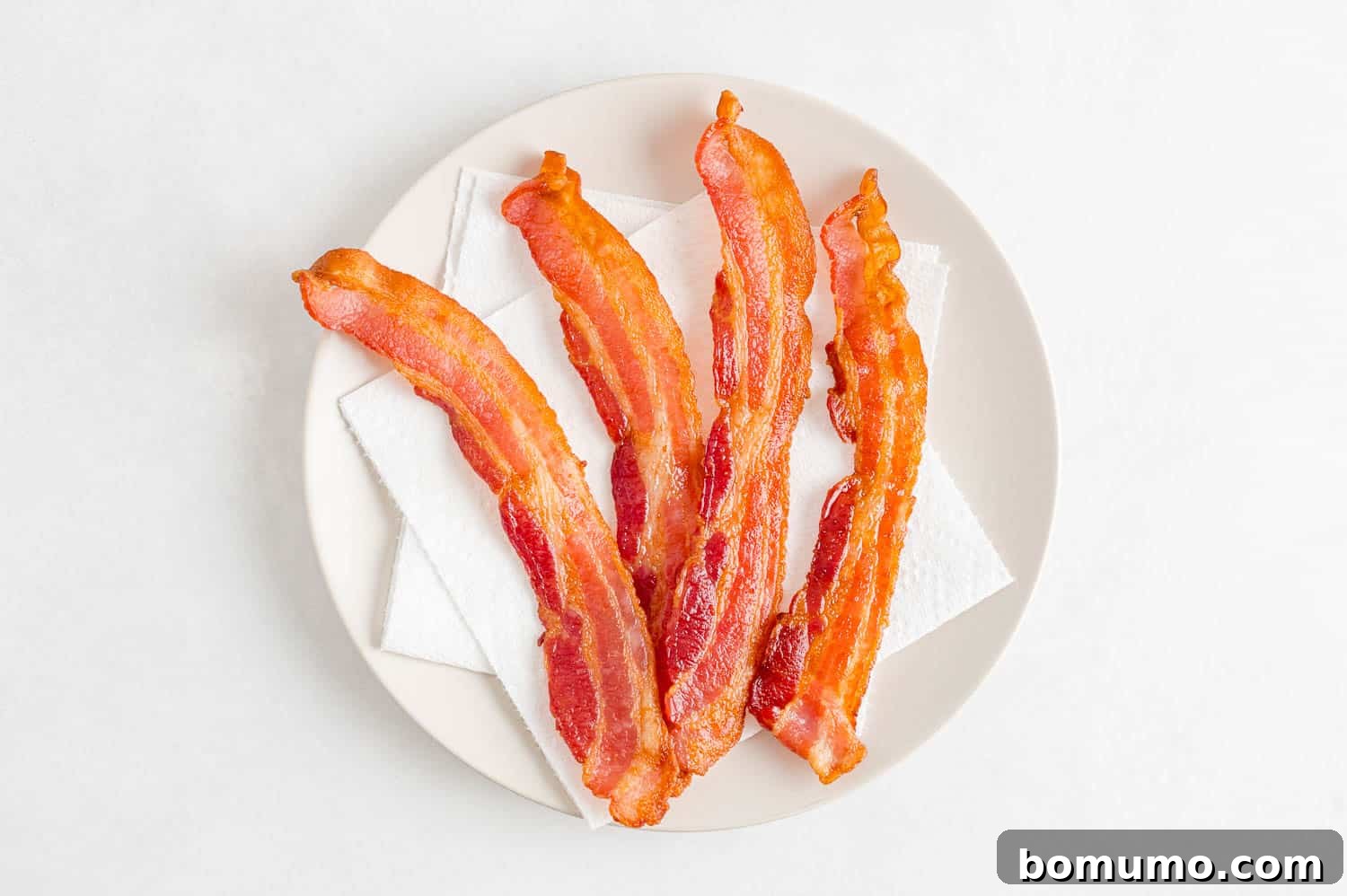 Crispy Air Fried Bacon 9 Freshly cooked, crispy bacon slices draining on paper towels.