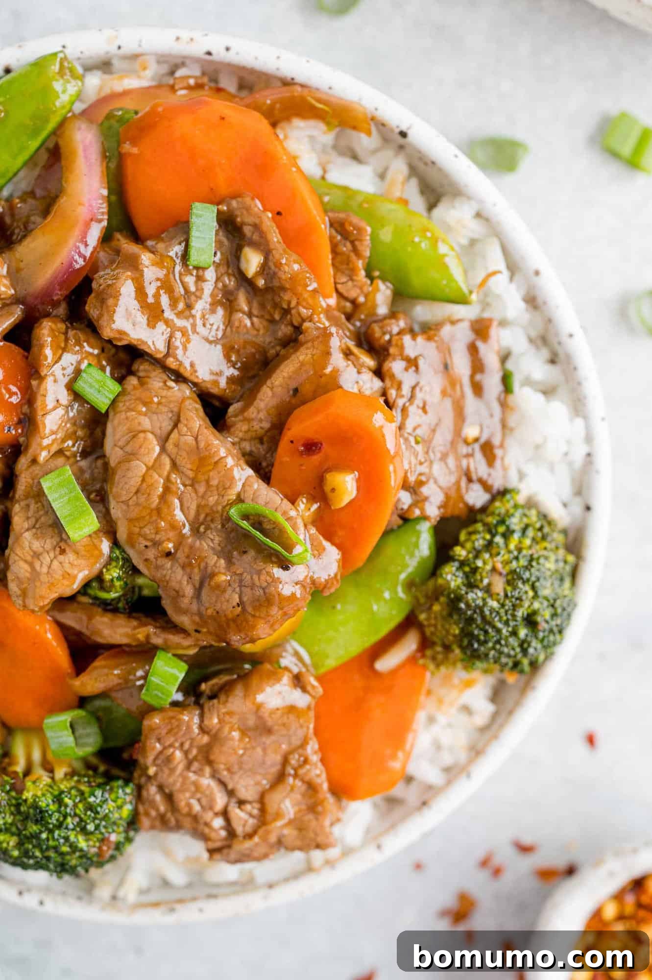 Beef stir fry with vibrant vegetables served on a bed of fluffy white rice.