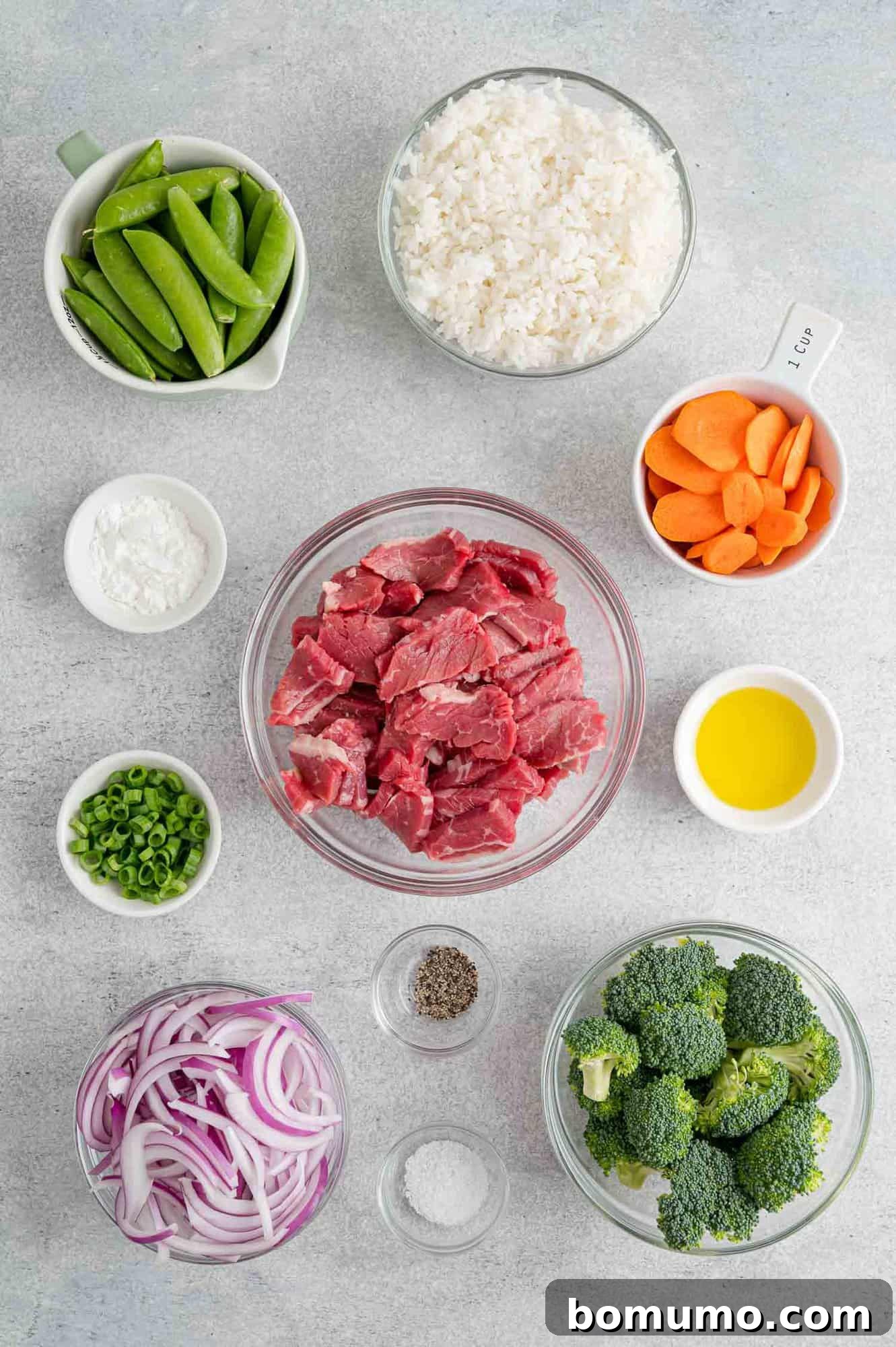 Overhead view of all ingredients meticulously prepped and laid out, including sliced beef and fresh vegetables.