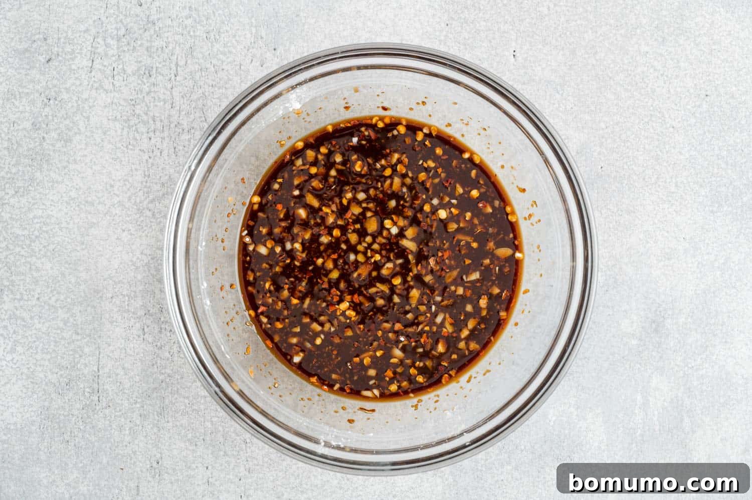A small glass bowl containing the freshly mixed stir-fry sauce, showcasing its rich color.