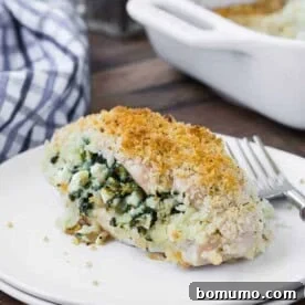 A beautifully breaded chicken breast, artfully sliced to reveal a savory filling of creamy feta and fresh spinach, ready to be enjoyed.