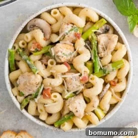 A comforting bowl of creamy chicken and asparagus pasta, rich and inviting with fresh green asparagus spears.