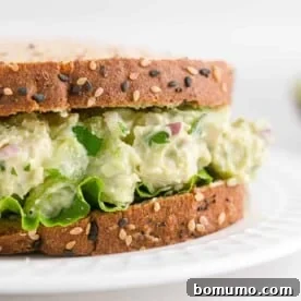 A hearty avocado chicken salad nestled between two slices of wholesome multigrain bread, making for a satisfying sandwich.