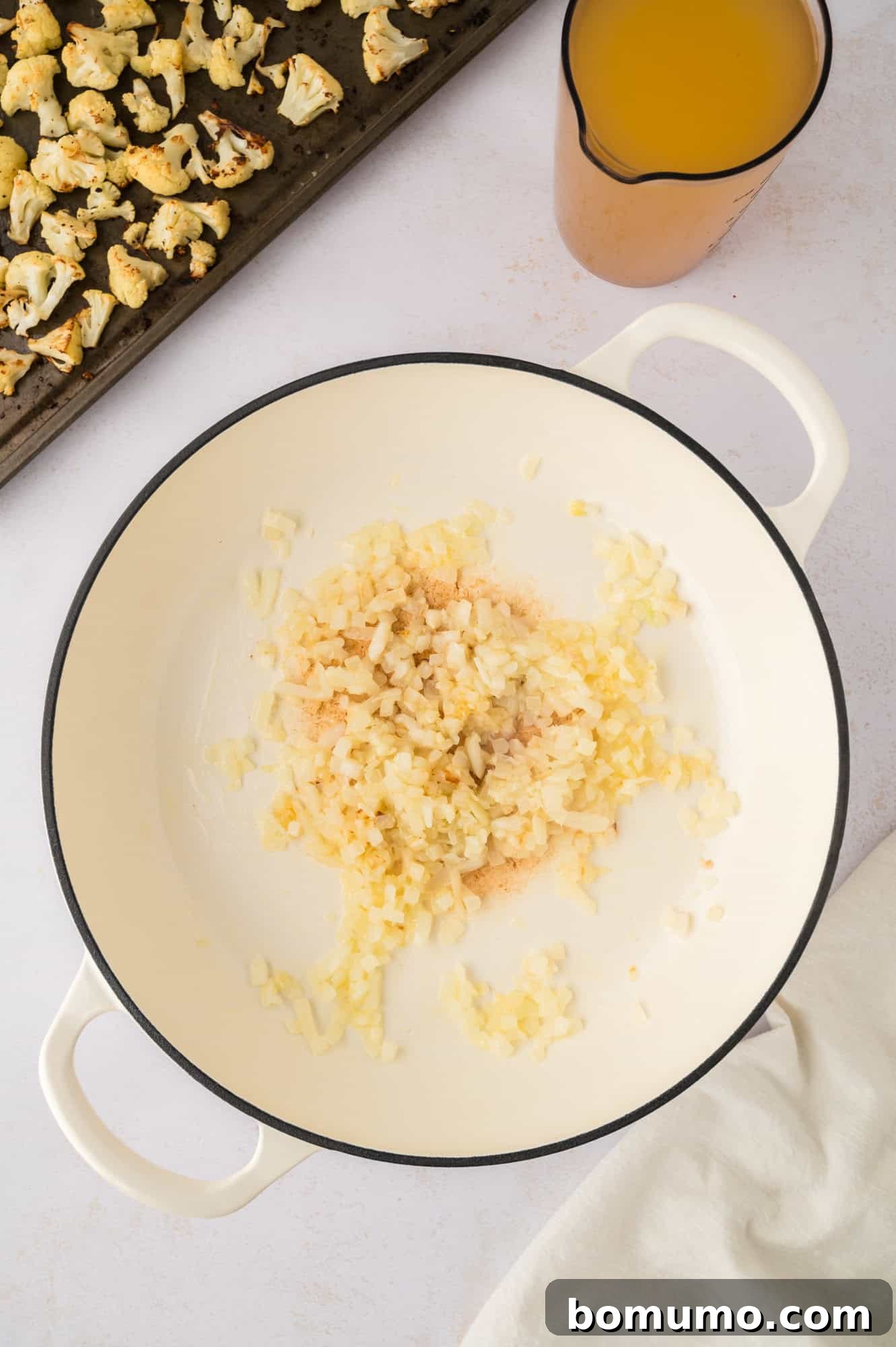 Sautéed onions and garlic, perfectly translucent and fragrant, forming the aromatic foundation of the soup.