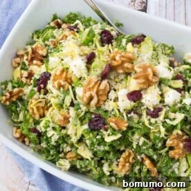 This healthy and hearty kale quinoa salad, featuring crunchy walnuts and sweet cranberries, stores well for meal prep.