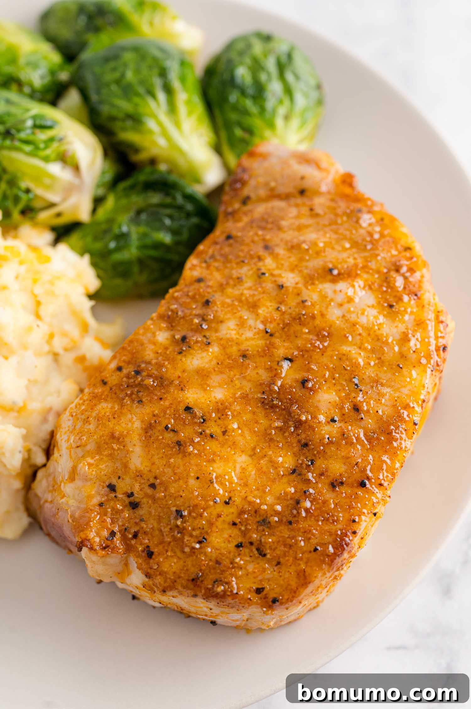 Air fryer pork chop with Brussels sprouts and potatoes, a perfect, quick dinner.