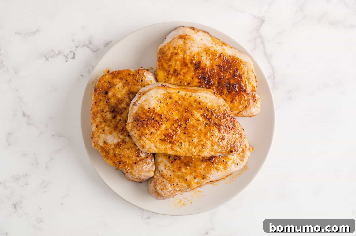 Cooked air fryer pork chops resting on a serving platter.
