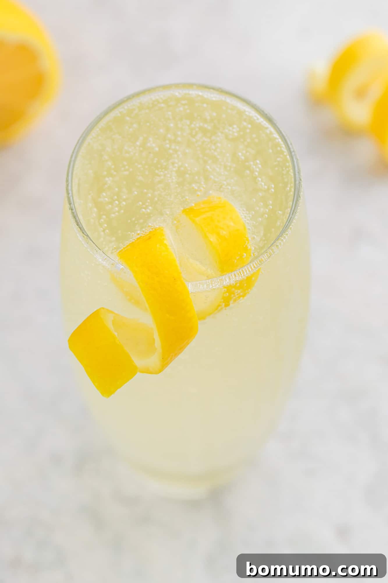 Lemon twist on a glass of lemon beverage.