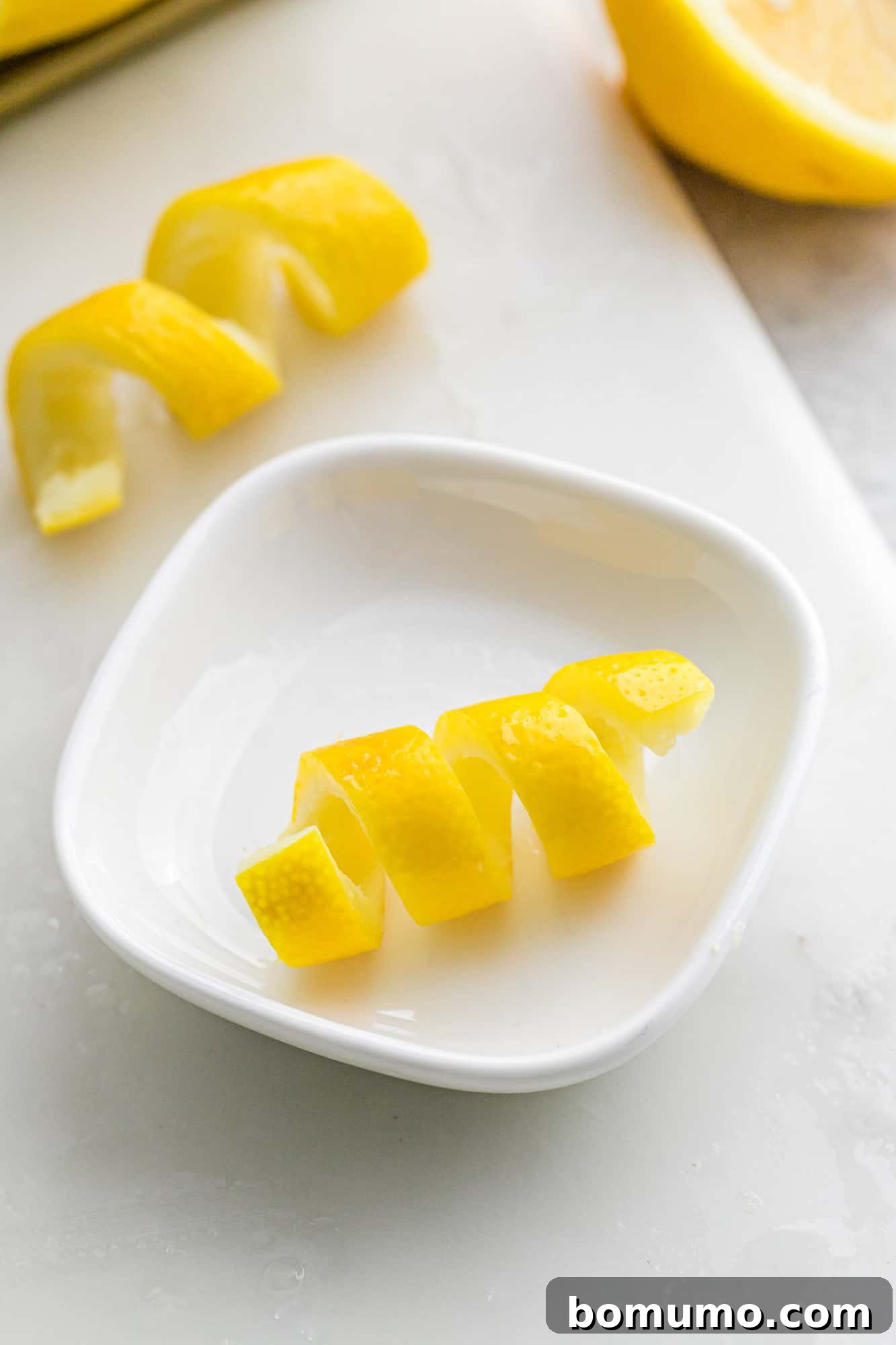 Lemon peel twist in a small white bowl.