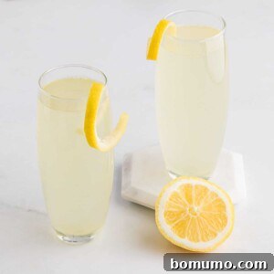 Two beautifully presented French 75 cocktails, each adorned with an elegant lemon twist, against a softly lit background, capturing their refreshing and sophisticated essence.