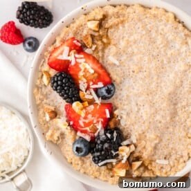 A beautiful bowl of breakfast quinoa, generously topped with an assortment of fresh berries and a sprinkle of nuts, ready for a healthy start to the day.