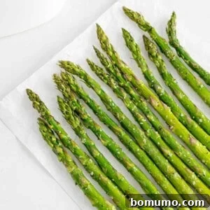 Air fryer asparagus laid flat on a white surface, showcasing its vibrant color and readiness for serving.