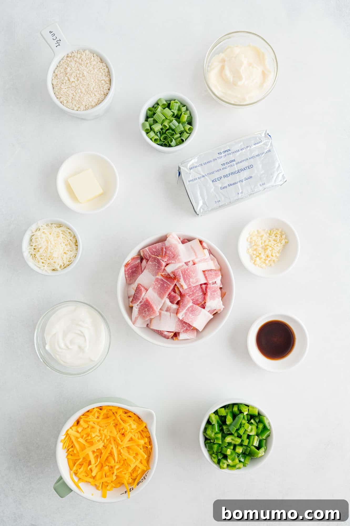 Overhead view of ingredients, including bacon, cheese, jalapeño, and other fresh produce, neatly arranged.