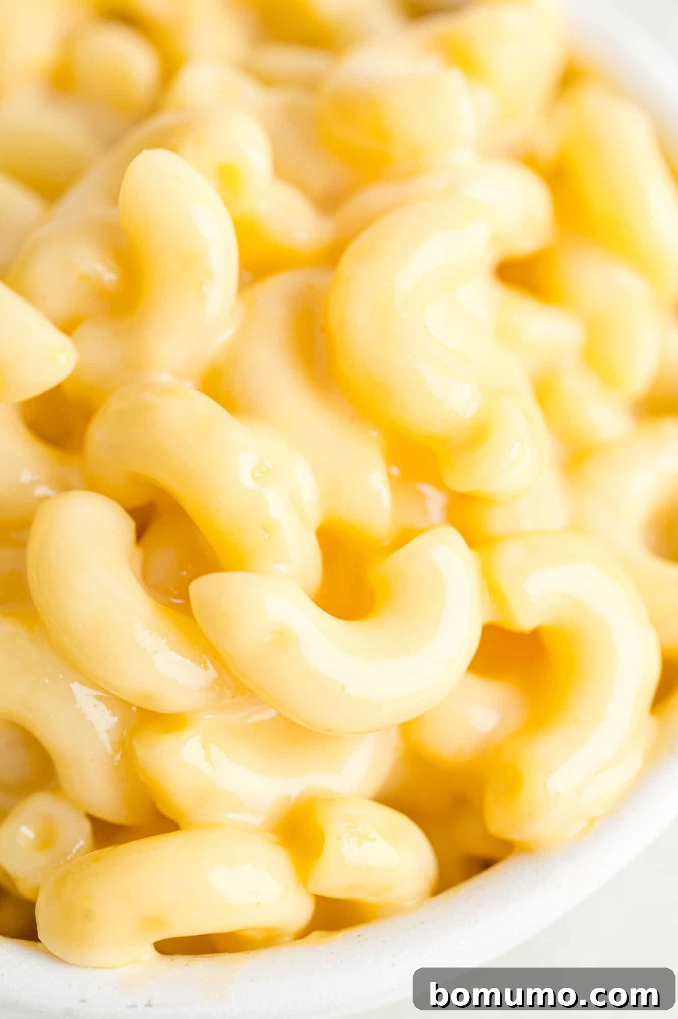 Close up image of microwave mac and cheese, highlighting its creamy texture.