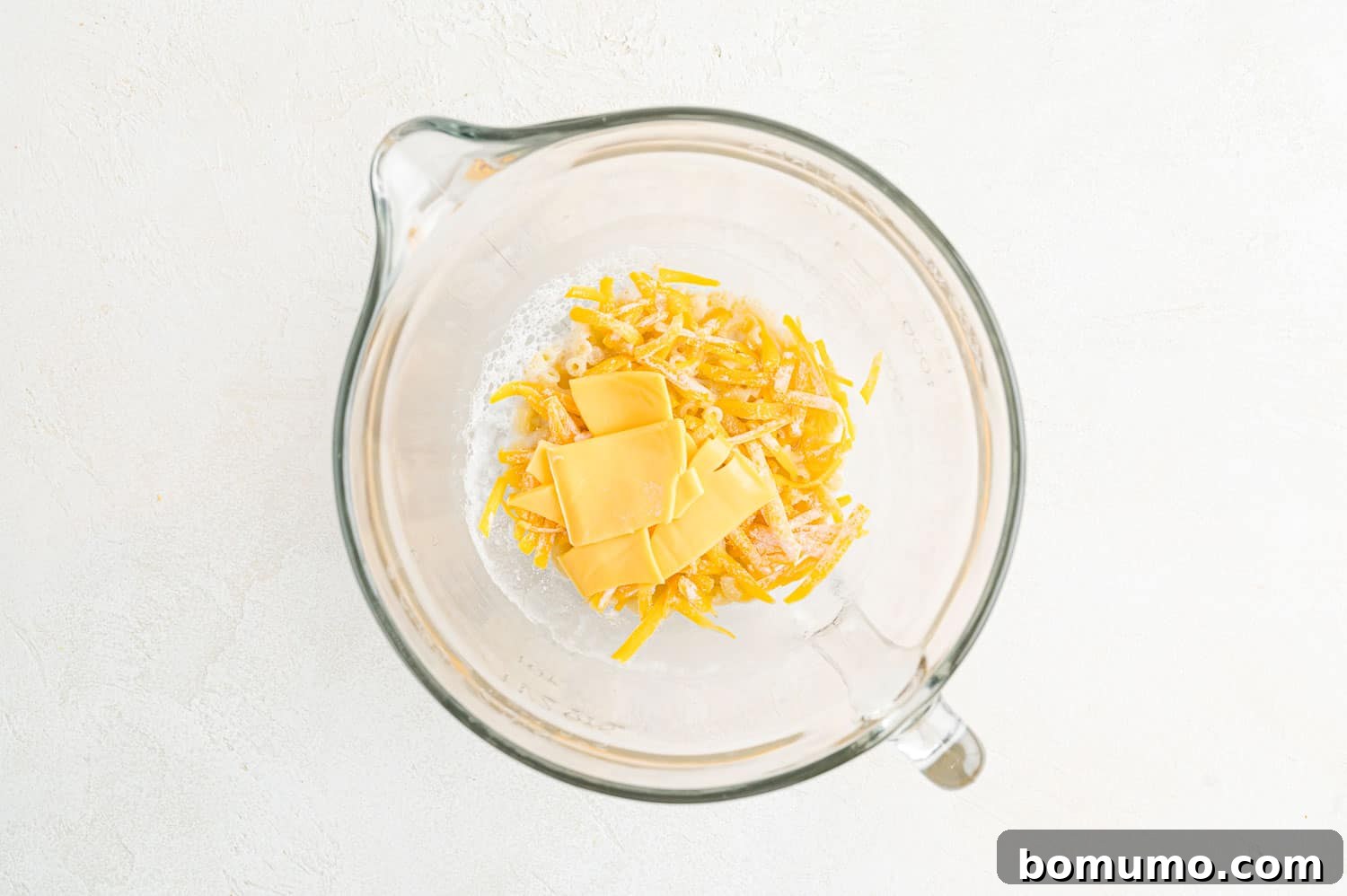 Macaroni and cheese with unmelted cheese on top, before stirring.