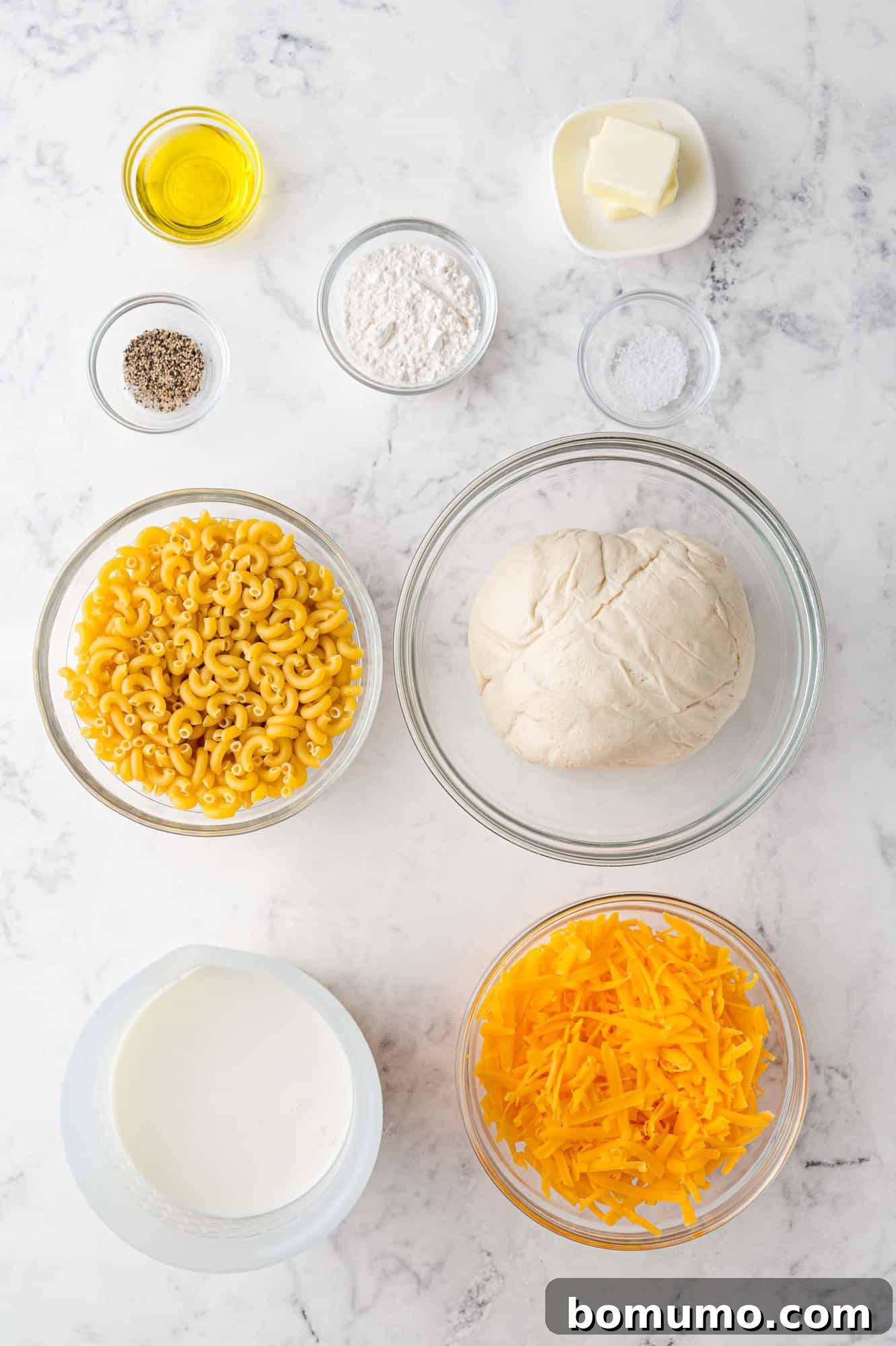 Ultimate Comfort Pizza 4 An overhead view of all the essential ingredients laid out on a clean surface, ready for preparing the mac and cheese pizza.