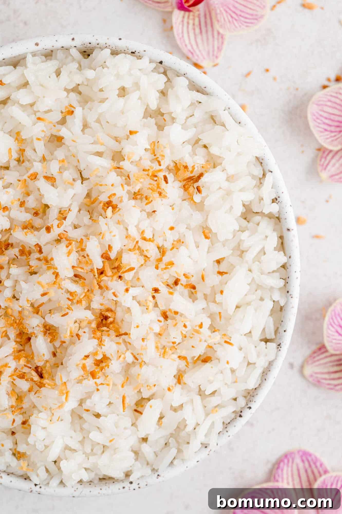 Tropical Coconut Bliss 2 Delicious coconut rice served in a pristine white bowl, beautifully garnished with golden toasted flaked coconut.