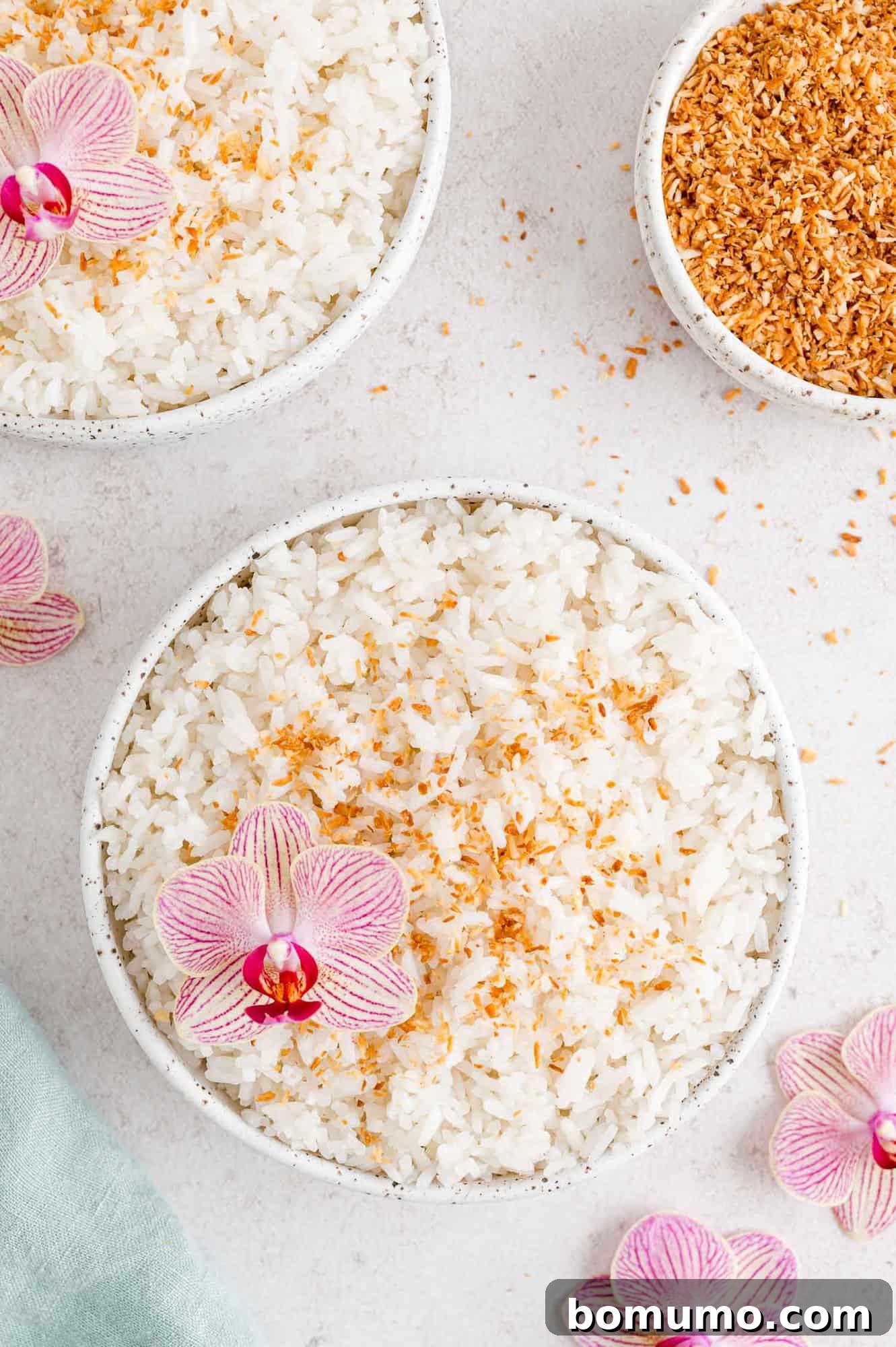 Tropical Coconut Bliss 10 A beautifully presented bowl of coconut rice, adorned with toasted coconut flakes and a delicate pink orchid.