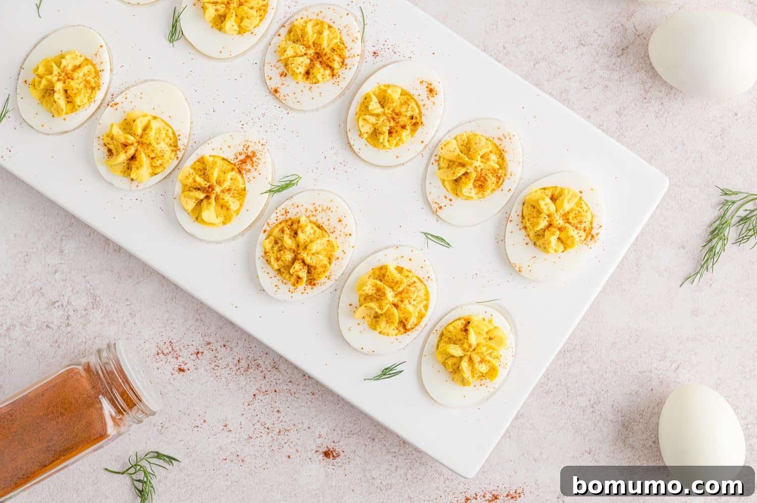 Deviled eggs garnished with paprika and dill.