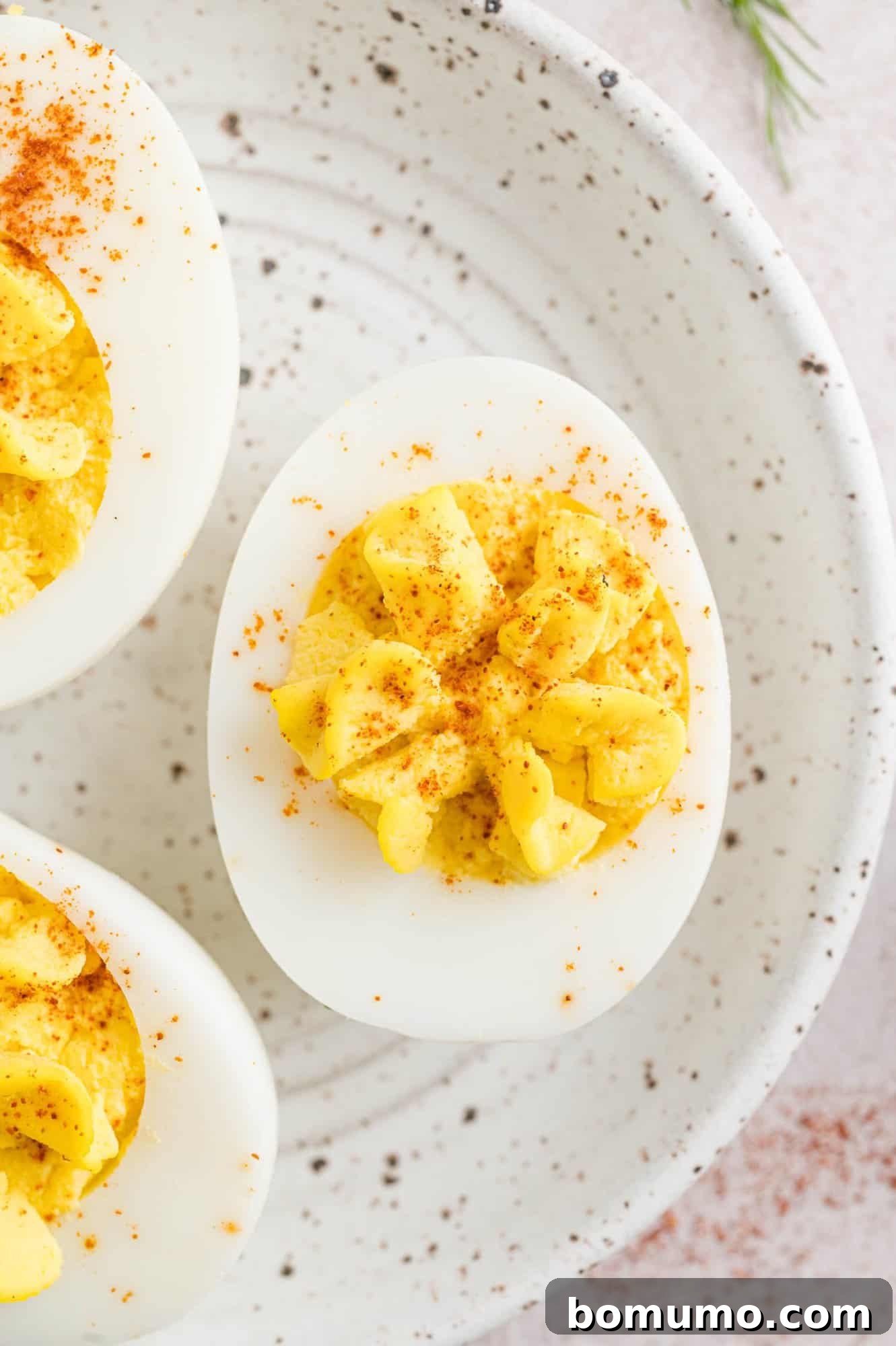 Deviled eggs on a speckled plate.