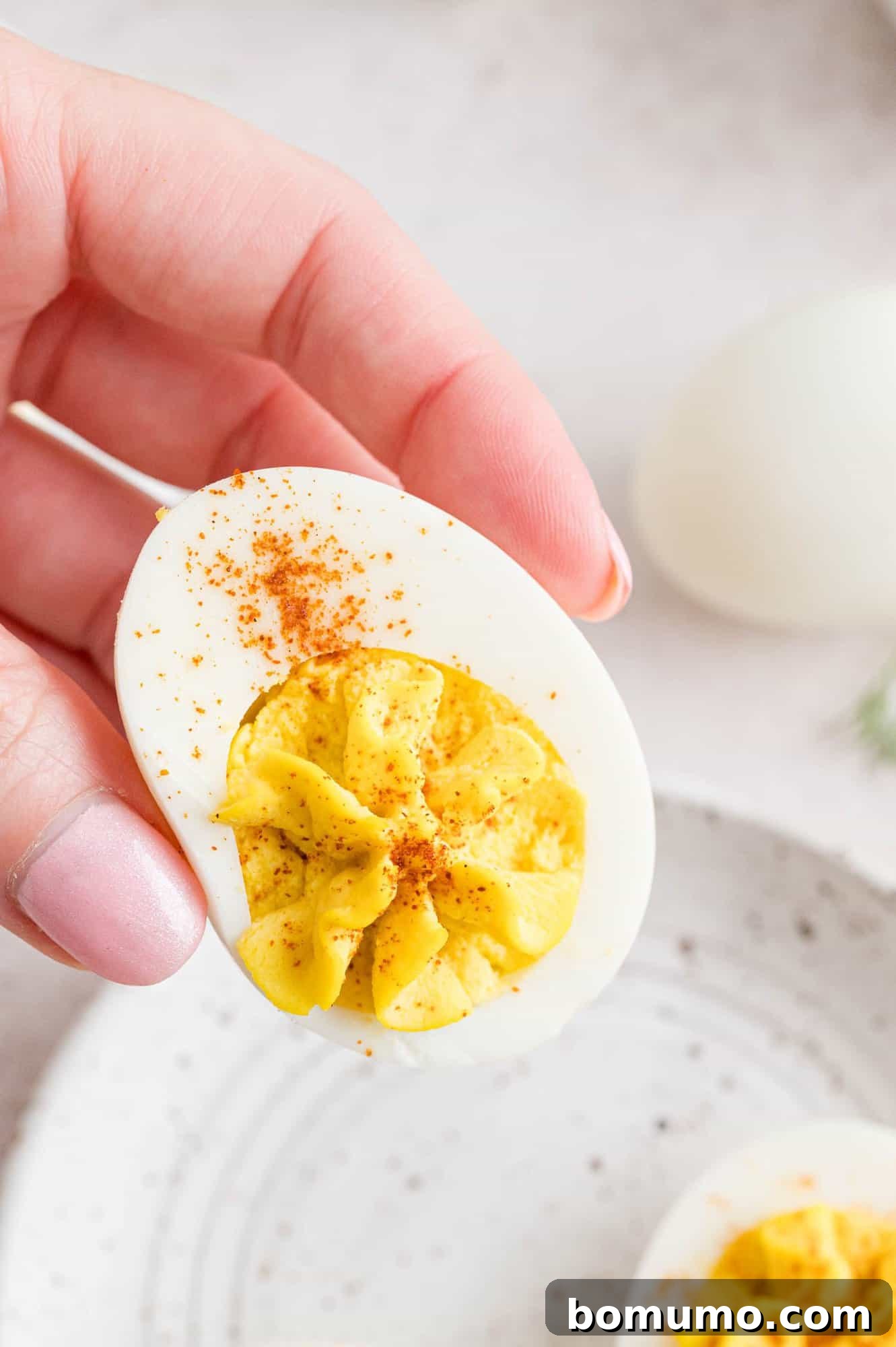 Deviled egg held in a hand.