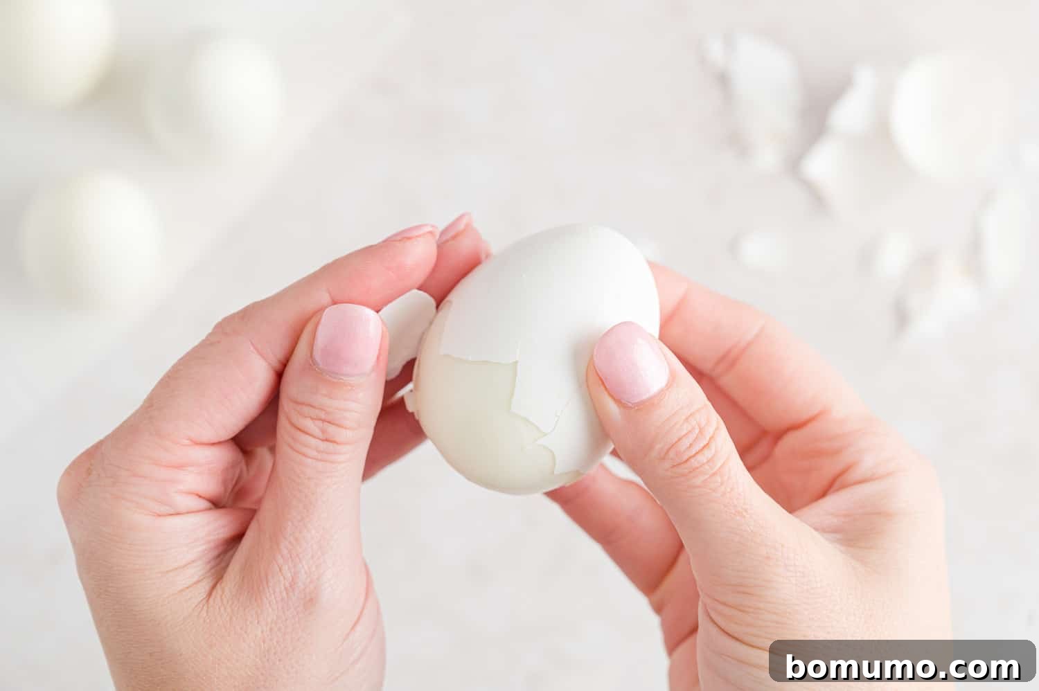 Boiled egg being peeled.