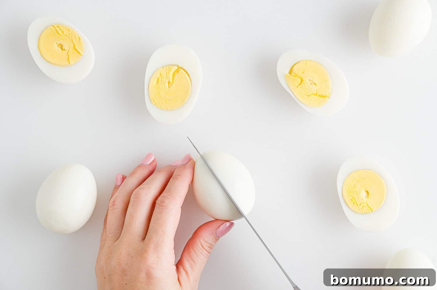 Boiled eggs being cut in half.
