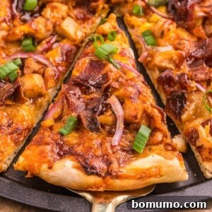 Slice of bbq chicken pizza being removed from pan.
