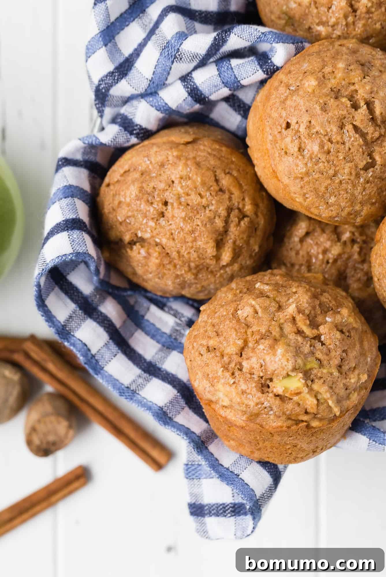 Overhead view of muffins in a basket with blue and white linen.