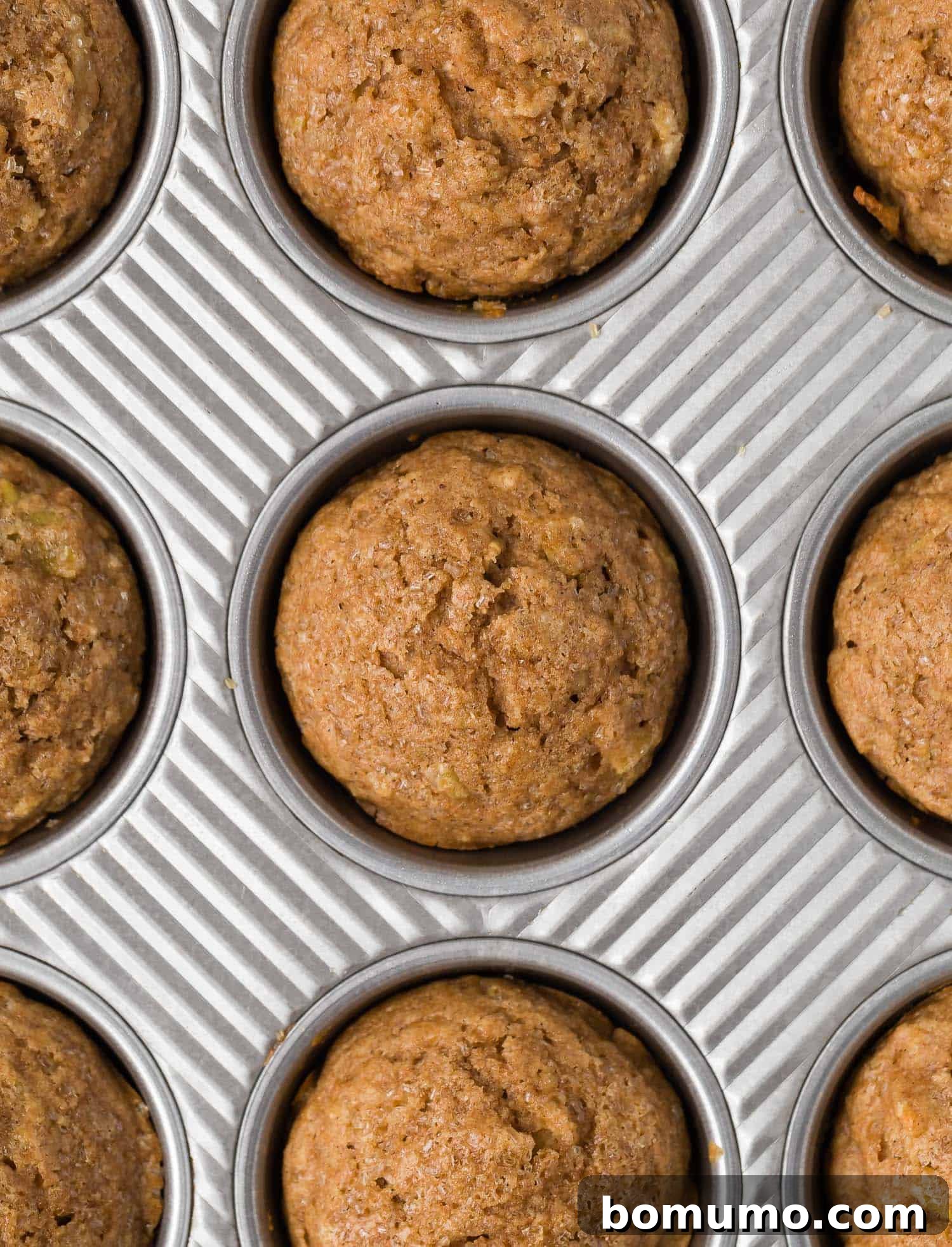 Overhead view of apple cinnamon muffins in a muffin tin.