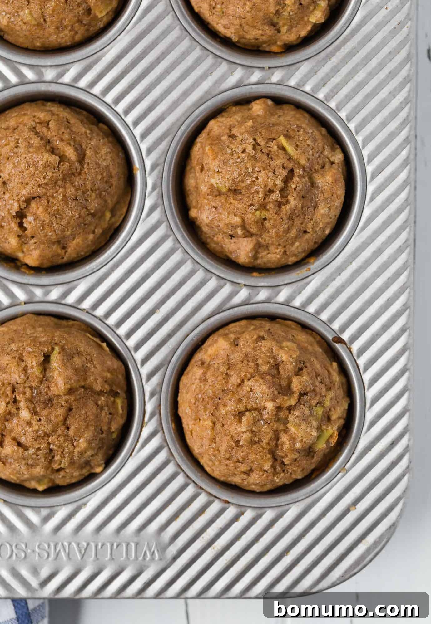 Overhead image of apple cinnamon muffins in a muffin tin.