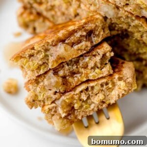Apple quinoa pancakes on a fork with syrup, highlighting their deliciousness.