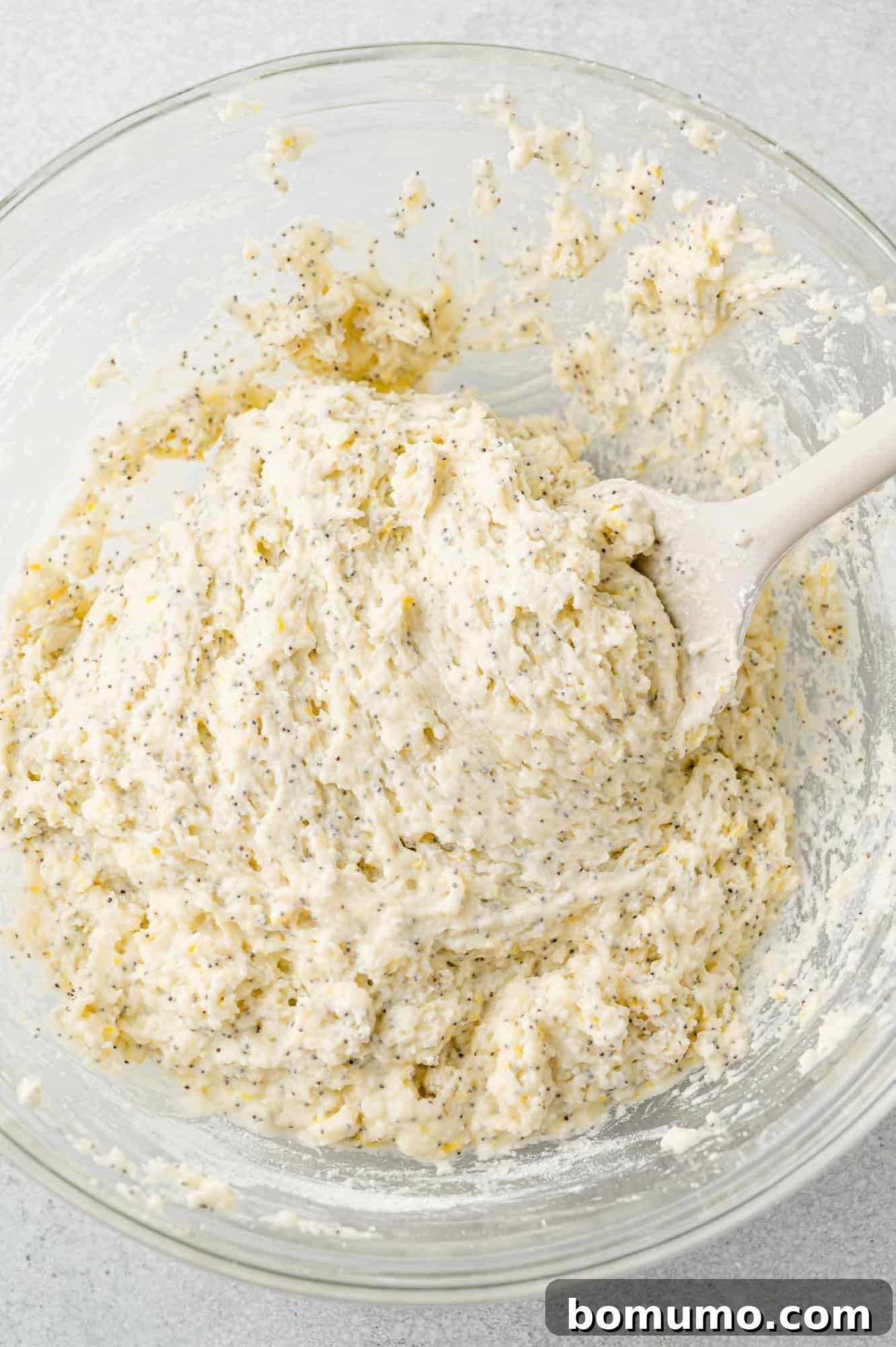 The lemon poppy seed bread batter fully mixed, showing its thick and cohesive texture with distributed poppy seeds.