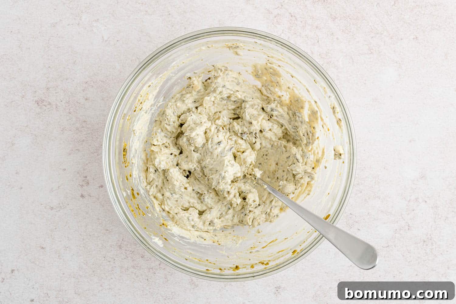 The cheese and pesto filling, after being thoroughly mixed, showing a smooth, creamy texture.