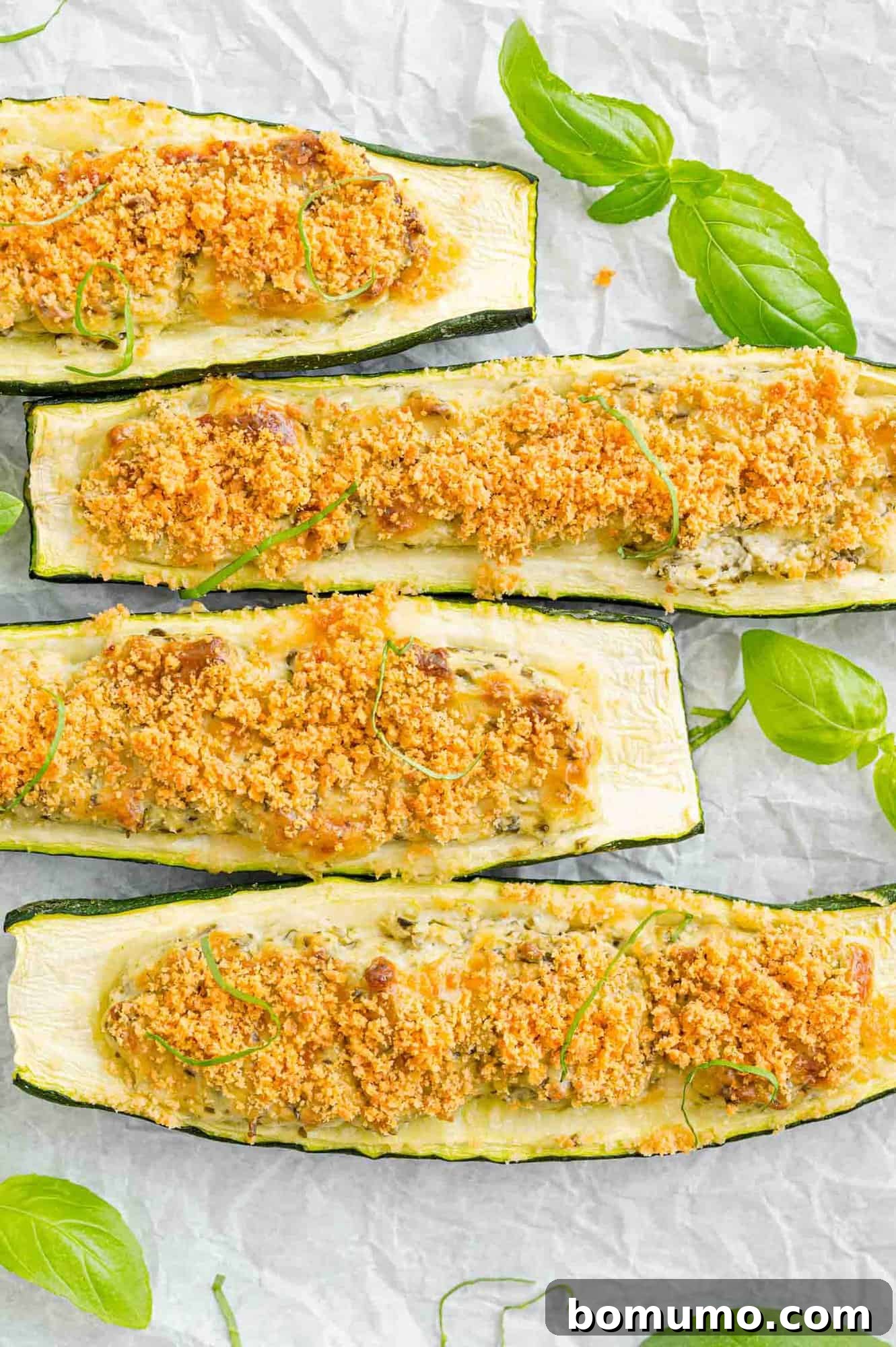 Baked zucchini halves topped with golden-brown Parmesan cheese, fresh out of the oven.
