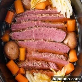 A hearty slow cooker corned beef and cabbage dish, beautifully arranged with tender carrots and potatoes, creating a complete and satisfying meal.