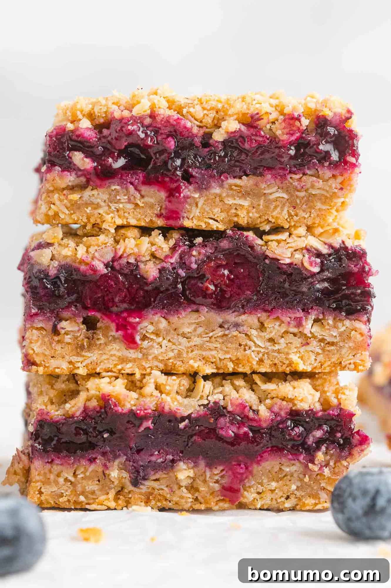 A stack of perfectly golden and fruity blueberry crumb bars.