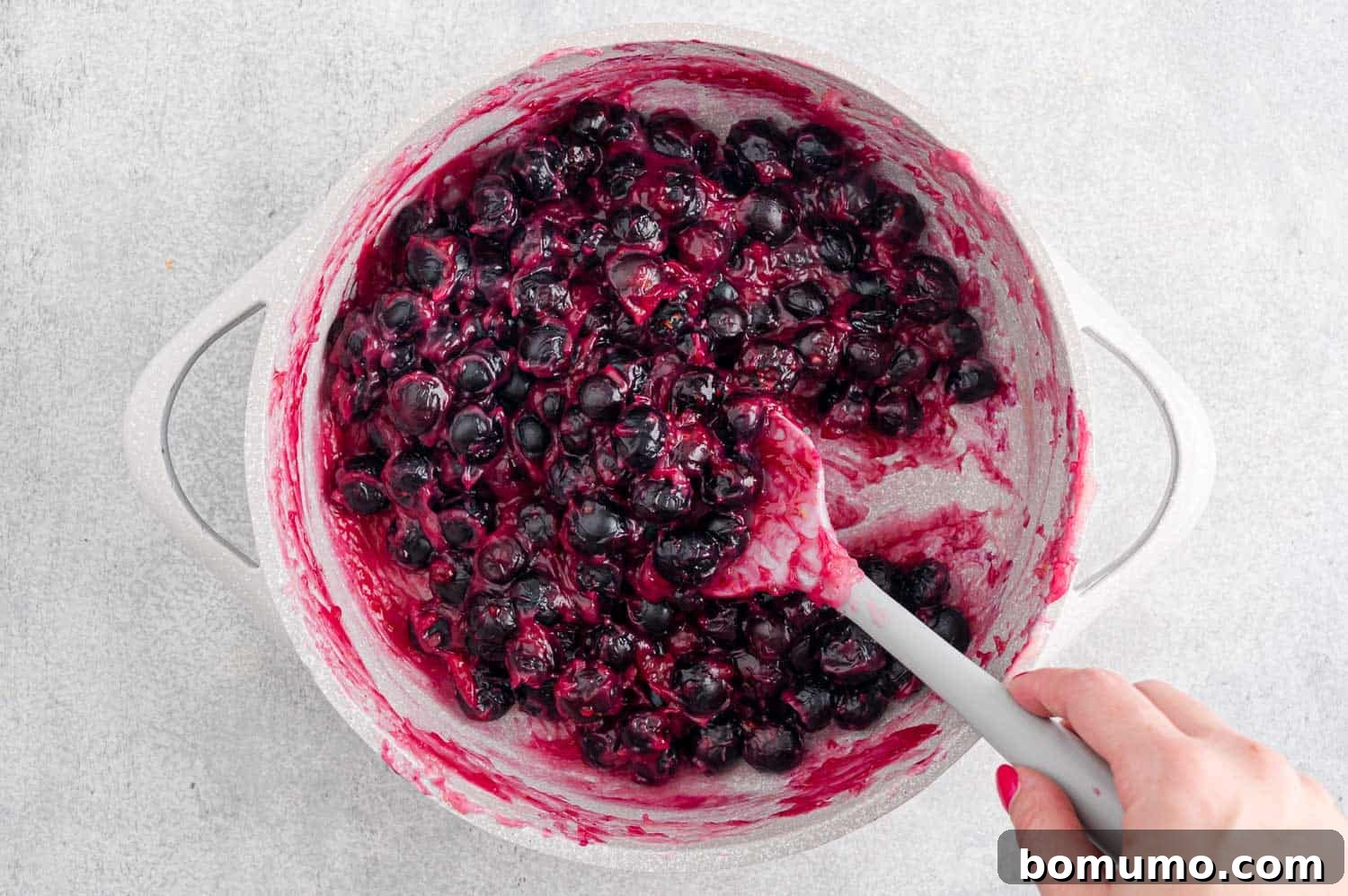 Cooked blueberry filling simmering in a saucepan.