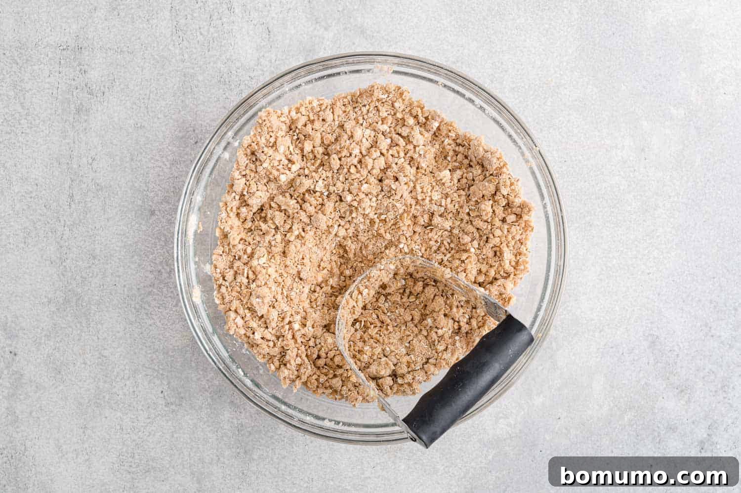 The butter and dry ingredients have been cut together, forming a crumbly, sand-like mixture.